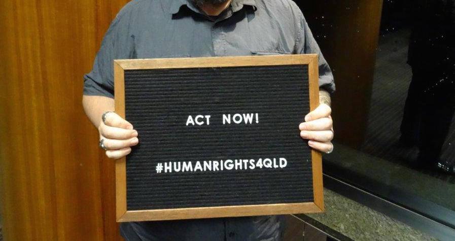 A person holding up an act now sign