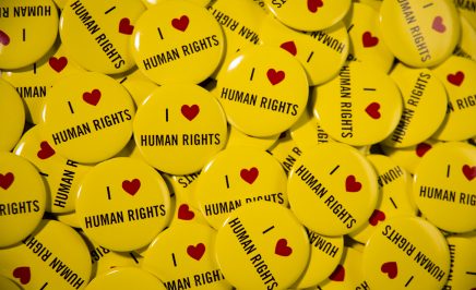 Hundreds of yellow badges with 'I heart human rights' printed on them.