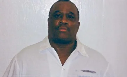 man with white shirt stares into camera